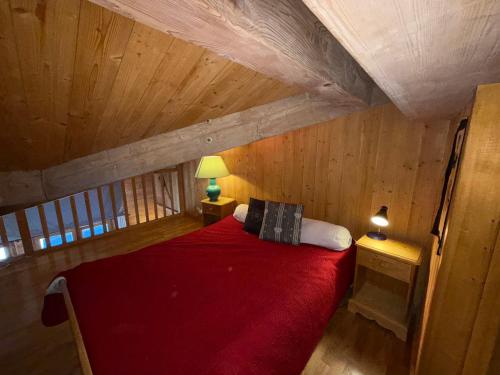 - une chambre mansardée avec un lit rouge dans l'établissement Appartement 2 pièces avec balcon sud, 4-5 pers, Les Saisies - FR-1-293-236, à Hauteluce