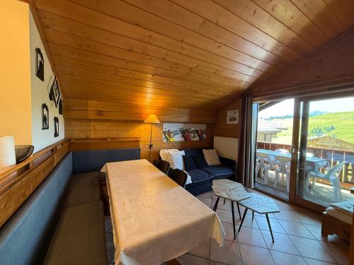 Cette chambre comprend une table, un canapé et une fenêtre. dans l'établissement Appart 4 pièces avec accès piscine, 8 pers, garage, balcons sud - FR-1-293-350, à Hauteluce