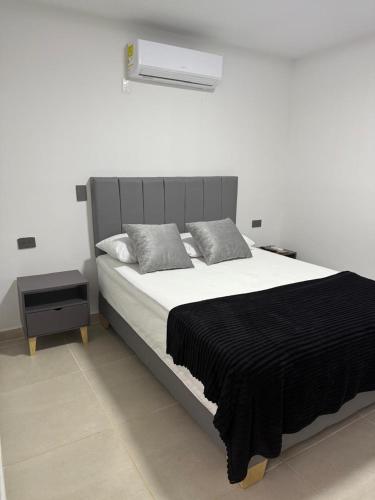 a bedroom with a large bed with a black blanket at Hotel De León Estadio in Medellín