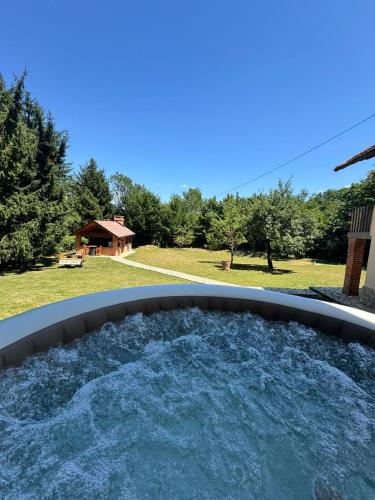 Un jacuzzi en un patio trasero con vista a un jardín. en Rancbl, en Banja Luka