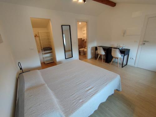 a bedroom with a large white bed and a table at Affittacamere il Ciliegio in Trieste