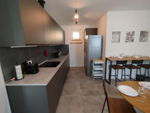 a kitchen with a counter and a table and a refrigerator at Affittacamere il Ciliegio in Trieste