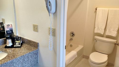 a bathroom with a toilet and a phone on the wall at Lewis River Inn in Woodland