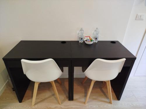 a black table with two white chairs in a room at Affittacamere il Ciliegio in Trieste