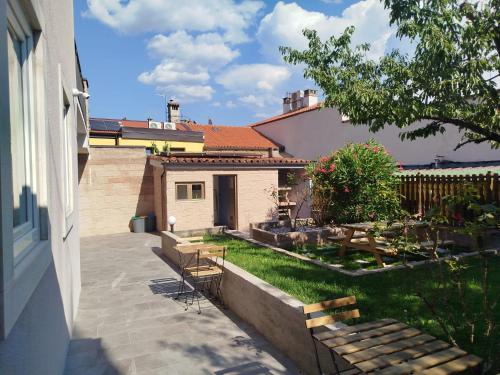 a backyard with two benches and a house at Affittacamere il Ciliegio in Trieste