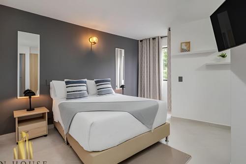 a bedroom with a large bed with white sheets and pillows at Aria Living 300 - Style and Urban Comfort in Guayaquil
