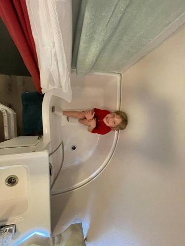 a man standing in a bath tub in a bathroom at Streamside Shinytiny Airstream In The Smokies in Cosby