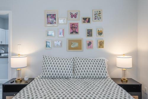 a bedroom with a bed with two lamps and pictures on the wall at Texas Casita Retreat Minutes From Six Flags in San Antonio