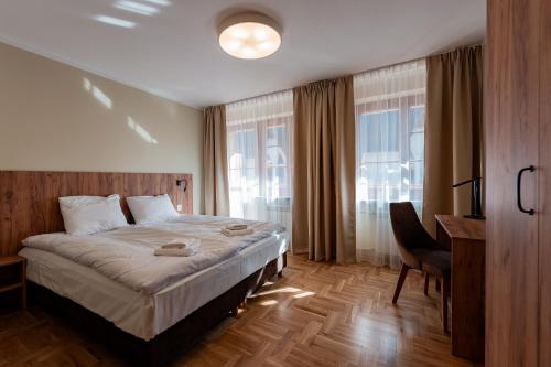 a hotel room with a bed and a desk and window at Gwiazda Tatr - ośrodek rekolekcyjno - wypoczynkowy in Zakopane