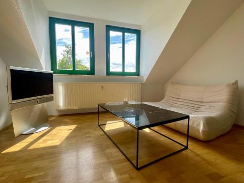a living room with a couch and a glass table at Zentrales hochwertiges Apartment Thomasius in Leipzig