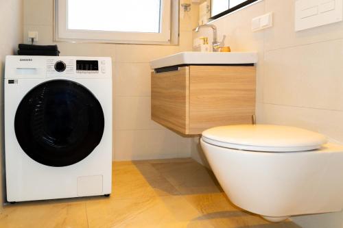 a washing machine in a bathroom with a toilet at Cozy apartment in central location in Wuppertal