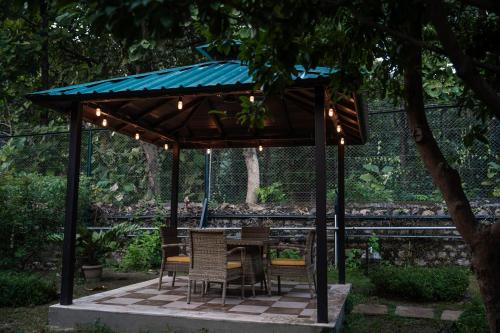 a gazebo with a table and chairs under it at Aahana Resort - Jim Corbett in Rāmnagar