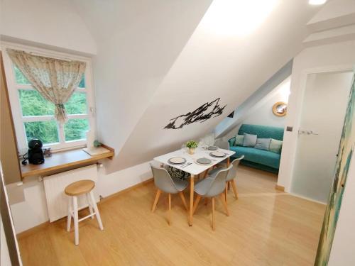 a dining room with a table and chairs and a couch at Apartament Górska Przystań - Willa Marysin in Bukowina Tatrzańska