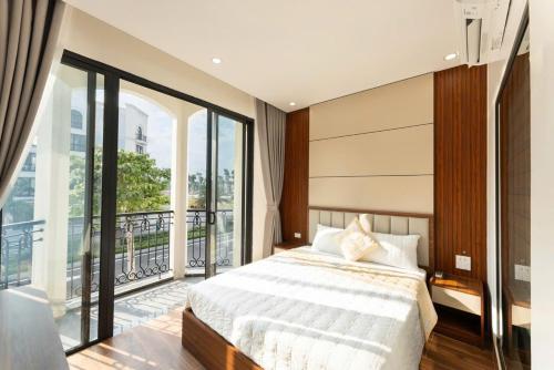 a bedroom with a large bed and a balcony at Ocean Hotel in Sầm Sơn
