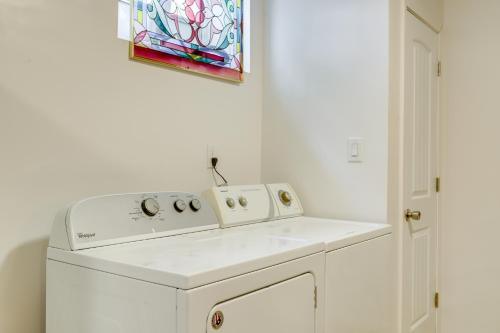 Una lavadora blanca en una cocina con una pintura. en 5 Mi to Trilith Studios Apt with Furnished Pergola, en Fayetteville
