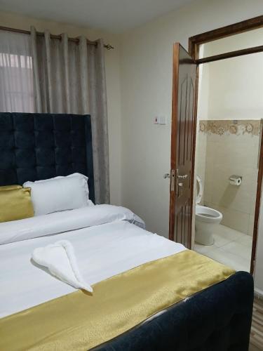 a bedroom with a bed and a bathroom with a shower at Kitengela two bedroom stays in Kitengela 