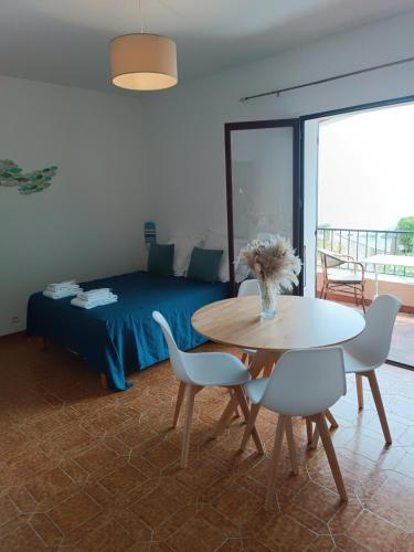 une chambre avec un lit, une table et des chaises dans l'établissement Studio vue mer, à Santa-Maria-di-Lota