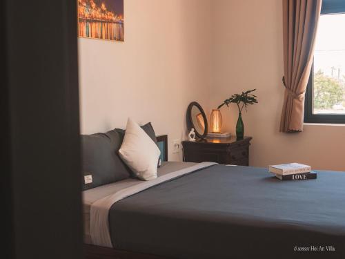a bedroom with a bed with a blue blanket and a window at 6 senses Hoi An Villa luxury 5BR 6bed and 5 minutes to An Bang beach in An Bang