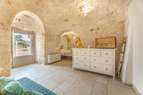 a bathroom with a white dresser in a stone wall at Trullo Aia Antica in Ceglie Messapica