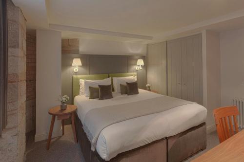 a bedroom with a large white bed with pillows at Old Town Chambers, Autograph Collection in Edinburgh