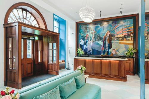 a living room with a blue couch and a large painting at Old Town Chambers, Autograph Collection in Edinburgh