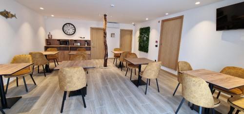 a restaurant with tables and chairs and a clock on the wall at Foz House Sabor & Douro in Torre de Moncorvo