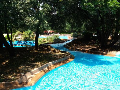 un toboggan aquatique dans un complexe hôtelier avec de l'eau bleue dans l'établissement Charming small house close to Uzès, à Foissac