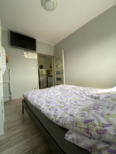 a bedroom with a bed with a purple comforter at Lawendowy Gościniec II in Białogóra