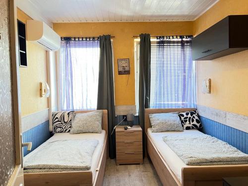 a small room with two beds and a window at Sailor's Apartman in Siófok