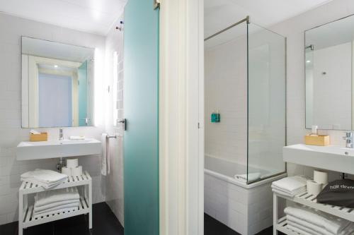 Un baño con dos lavabos y una ducha. en Durlet Beach Apartments, en Barcelona
