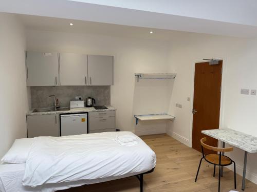a small room with a bed and a kitchen at Central London Budget Rooms in London