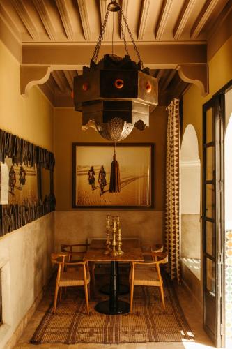 马拉喀什里亚德代尔庭院旅馆的一间有桌子和枝形吊灯的餐厅