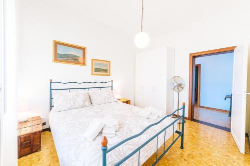 a white bedroom with a bed and a window at Casa ElleBi fronte spiaggia con posto auto gratuito in Pesaro