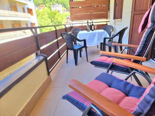 a balcony with chairs and a table and a table and chairs at GIULY Apartment in Aprica
