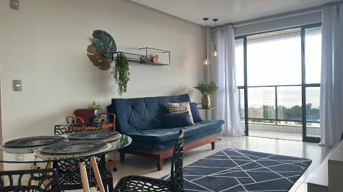 a living room with a blue couch and a table at (1209)Studio com vista panorâmica mar in São Luís