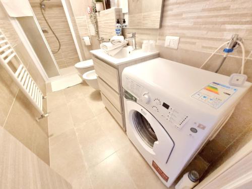 a bathroom with a washing machine and a sink at GIULY Apartment in Aprica