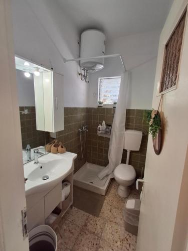Un baño con lavabo, inodoro y ducha. en The Hidden Home Keri, en Marathias