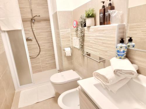 a bathroom with a toilet and a shower and a sink at GIULY Apartment in Aprica