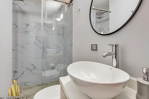 a white bathroom with a sink and a mirror at Aria Living 200 - Vibrant Apartment in Laureles in Guayaquil