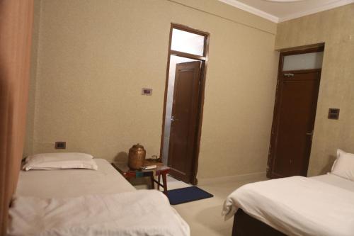 a room with two beds and a window in it at Vedic Dham Ganga in Rishīkesh