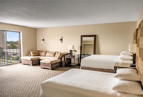 a hotel room with two beds and a couch at Hyatt Regency Green Bay in Green Bay