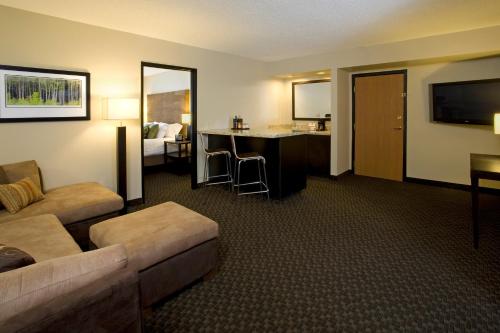 a living room with a couch and a desk in a hotel room at Hyatt Regency Green Bay in Green Bay