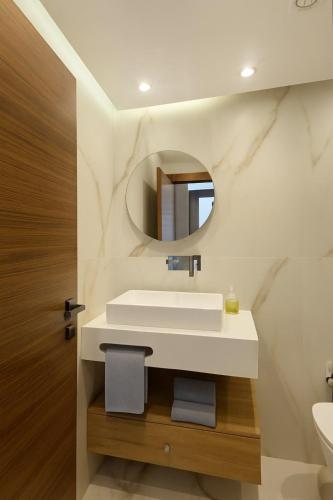 a bathroom with a white sink and a mirror at CHU -Family Apartment in Tangier in Daidatz