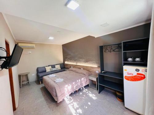 a bedroom with a bed and a refrigerator in it at Cabañas Villa de Luján in San Rafael
