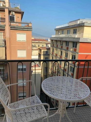 a table and chairs on a balcony with buildings at Maison de luxe in Naples