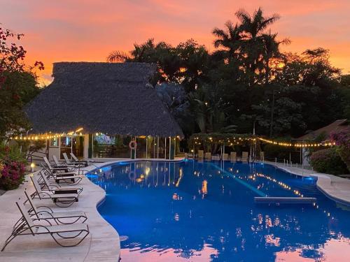 a swimming pool with lounge chairs and a resort at Seis Playas Hotel in Tamarindo