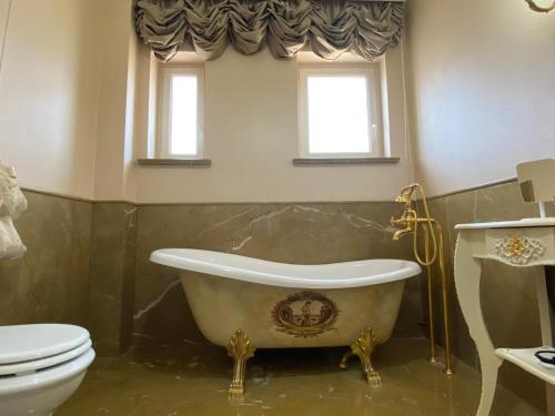 a bathroom with a tub and a toilet and windows at Maison de luxe in Naples
