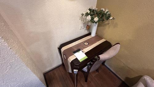 a table and a chair with a vase of flowers on it at Aayush Resort in Kālundri