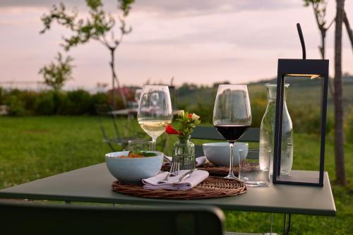 a table with glasses of wine and a bowl of food at Colle Alberti Country House in Cerreto Guidi