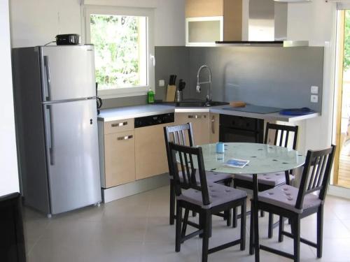 レ・マトゥにあるMaison familiale à Les Mathes avec jardin et saunaのテーブルと椅子、冷蔵庫のあるキッチン